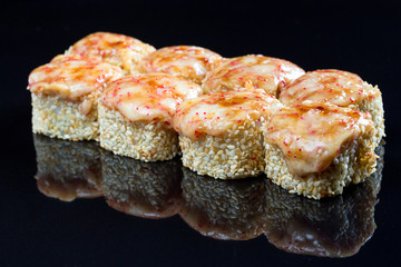 Sushi rolls with squid, mussel and cheese on a black background.