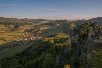 View of the countryside under the mountains at sunset.