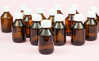 Brown medical bottles isolated on pink background.