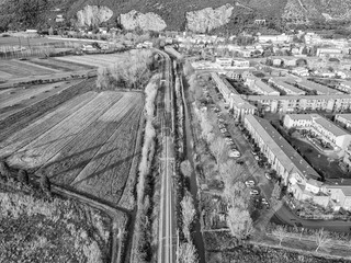 Aerial view from the drone of the railway that runs along a small town in Tuscany