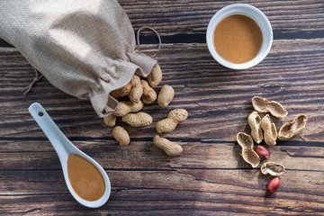 Peanuts and peanut butter on wooden background. Healthy snack. Top view.