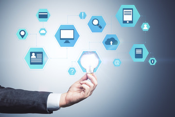 Hand holding lamp and business interface hologram.