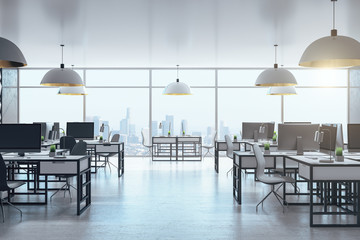 Modern office room with computers and panoramic city view.