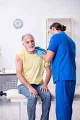 Fototapeta premium Injured old man visiting young male doctor traumatologist