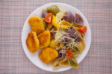 tasty appetizing pasta with chicken nuggets on white plate