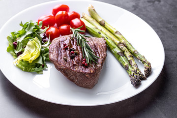 Steak on a white plate with vegetables