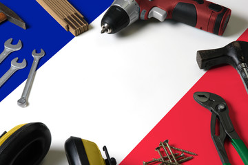 France flag on repair tool concept wooden table background. Mechanical service theme with national objects.