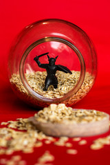 photo red background oatmeal in a jar and a black toy figurine gall