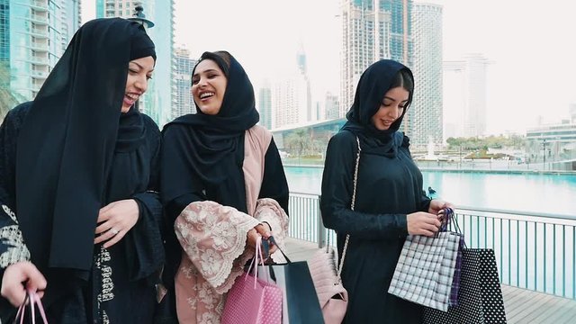 Three friends making shopping and spending time together in Dubai. Group of women wearing traditional uae abaya clothes outdoor