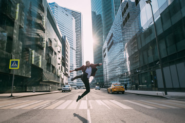 A man jumps over a pedestrian crossing in the business center of the city