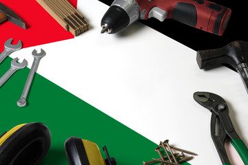 Palestine flag on repair tool concept wooden table background. Mechanical service theme with national objects.