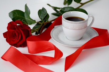 Red rose, red stripe, cup of coffee on plate, gray tea set on white table