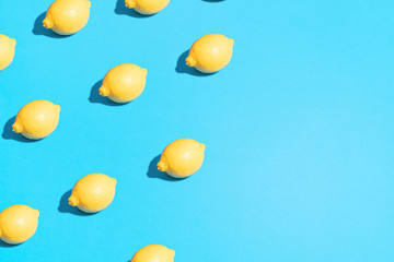 Minimal flat lay food texture. Summer abstract trendy fresh concept. Lemon pattern on bright light blue background, copy space.