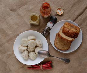 khinkali on the table with ketchup, pepper, bread and chili. Bon Appetit.
