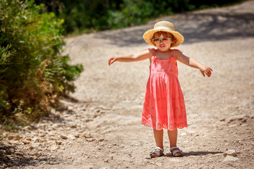Cute happy curly toddler girl walking outdoors