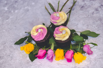 Pink and yellow cupcakes with fuchsia and yellow rose flowers
