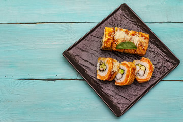 Grilled tiger prawn sushi. Japanese or Korean roll with different fresh ingredients. Trendy turquoise background
