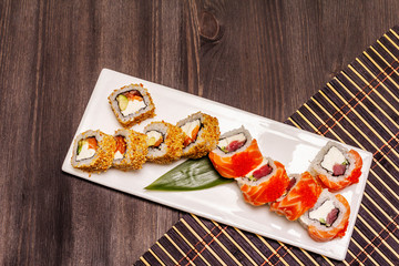 Assorted sushi set. Japanese or Korean roll with different fresh ingredients. Trendy black background