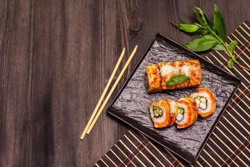 Grilled tiger prawn sushi. Japanese or Korean roll with different fresh ingredients. Trendy black background