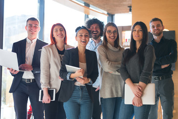 Fototapeta premium Portrait of successful creative business team looking at camera and smiling. Diverse business people standing together at startup.