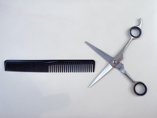 HAIRDRESSER'S TOOLS, A PAIR OF SCISSORS, A COMB AND A RAZOR