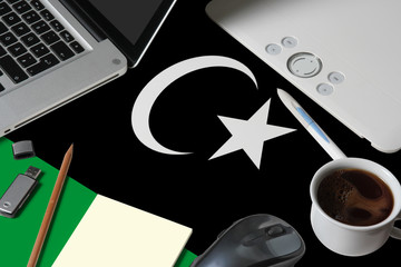 Libya national flag on top view work space of creative designer with laptop, computer keyboard, usb...