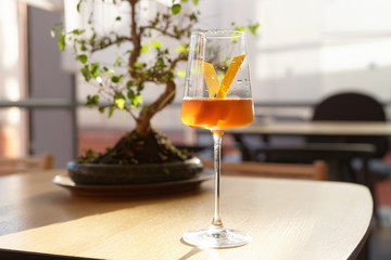 Japanese style cocktail with lemon zest in wineglass