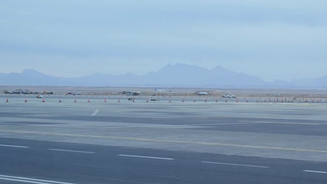 There is a Long Runway in the International Airport of the Hurghada City. You Can See an Aircraft That is Gaining Speed For Taking Off on the Runway.