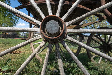 DALLIKON, SWITZERLAND - APRIL 18, 2020: A wooden wheel of a wooden vintage carriage from old times stands in front of a farm by the road