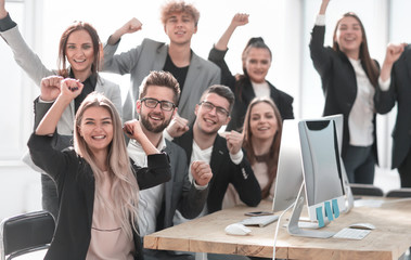 group of young professionals sitting at an office Desk.