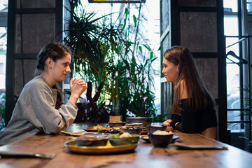 Two pretty young girls having thai or asian cuisine