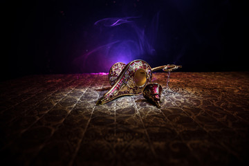 Lamp of wishes concept. Antique Aladdin arabian nights genie style oil lamp with soft light white...