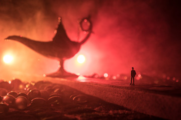 Silhouette of a man standing in the middle of the road on a misty night with giant Antique Aladdin...