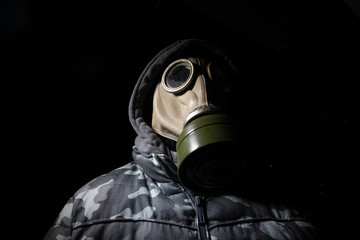 Gas mask with clouds of smoke on a dark background. Sign of radioactive contamination. Means for radiation protection. Danger of carbon monoxide poisoning.