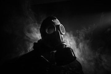 Gas mask with clouds of smoke on a dark background. Sign of radioactive contamination. Means for...