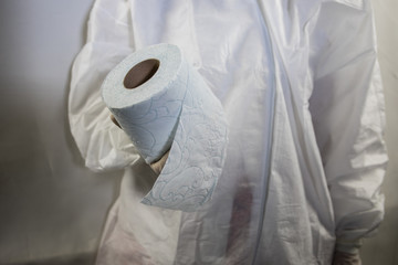 A woman is wearing a face mask for protection from the Corona Virus and has stocked up on her toilet paper stash in case of quarantine.