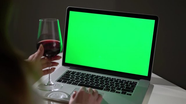 Woman working or using laptop computer with green screen chromakey display