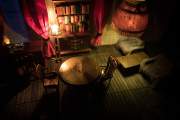 A realistic dollhouse living room with furniture and window at night. Artwork table decoration with handmade realistic dollhouse.