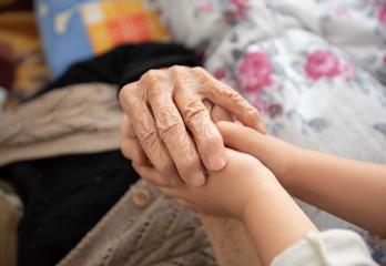 Old and child holding hands