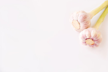 2 heads of young garlic on a white background