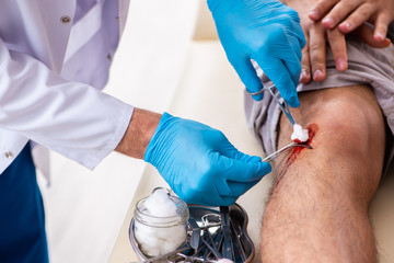 Leg injured man visiting old doctor in first aid concept