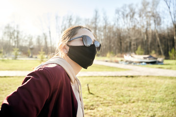 Girl in a medical mask. Coronavirus pandemic. Virus protection. Viral epidemic in the city. sunny weather