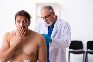 Injured young man visiting experienced male doctor