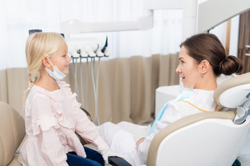 Obraz premium Little dentist patient talking to her doctor