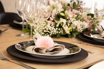 Elegant table setting with flowers and white and black dinnerware