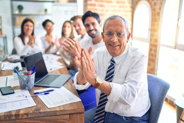 Group of business workers smiling happy and confident. Working together with smile on face looking at the camera applauding at the office
