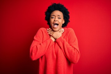 Fototapeta na wymiar Young beautiful African American afro woman with curly hair wearing casual sweater shouting and suffocate because painful strangle. Health problem. Asphyxiate and suicide concept.