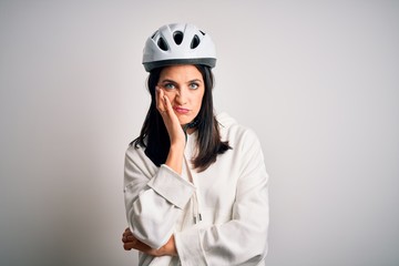 Young cyclist woman with blue eyes wearing bike helmet over isolated white background thinking looking tired and bored with depression problems with crossed arms.