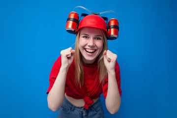 funny girl a fan in a red uniform and a beer hat watches the game and enjoy the victory, the winner screams and holds hands in fists