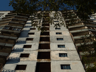 Abandoned residential building. Previous roads and alleys are taken by trees and bushes. Ghost town of Pripyat, Chernobyl Exclusion Zone. Ukraine.